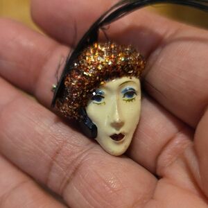 Artistic Glittered Face Brooch with Black Feather